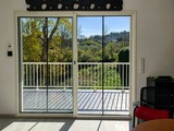 Baie vitrée coulissante blanche - Menuiserie aluminium installée par AIP à Vescovato