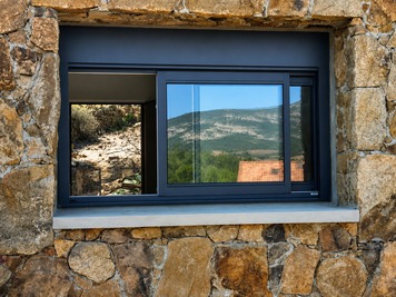 Fenêtre coulissante aluminium anthracite - Façade en pierre naturelle en Corse