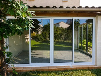 Véranda aluminium blanche avec baies vitrées - Extension lumineuse réalisée par AIP à Vescovato